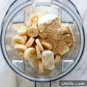 A blender filled with bananas and other ingredients, creating a delicious banana protein shake.