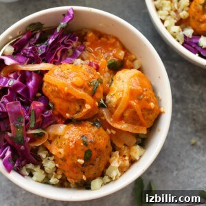 Two bowls with red curry meatballs and cabbage.