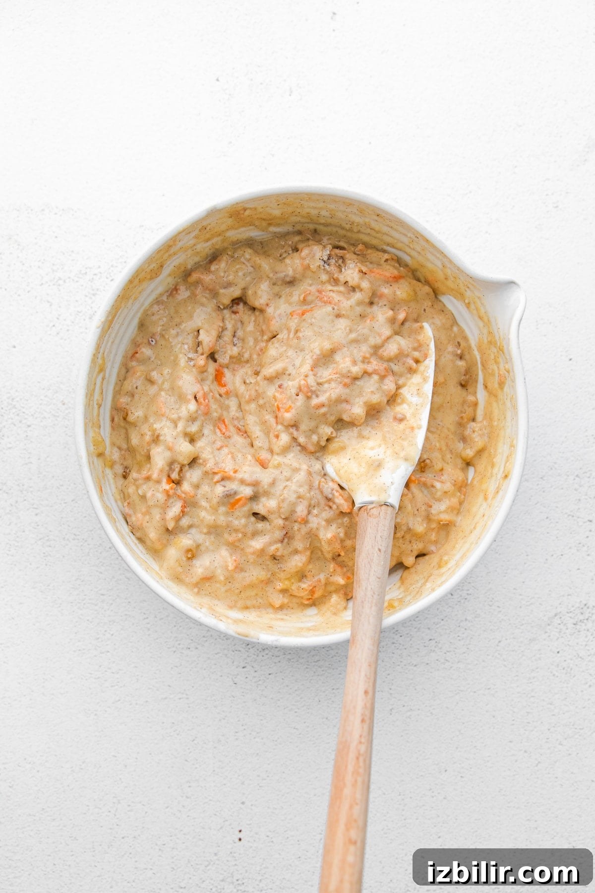 Take your muffin game up a notch with these easy whole grain carrot cake muffins. They're kid-friendly, naturally sweetened, and the perfect snack! Make a batch today! carrot muffin batter in bowl