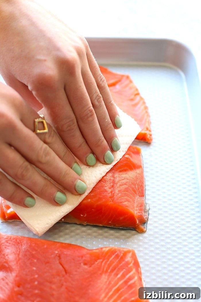 Pat salmon fillets dry before cooking hands patting salmon fillets dry