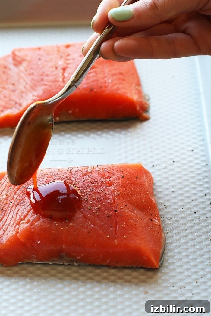 Pour the honey sriracha glaze over salmon honey sriracha sauce being poured over salmon