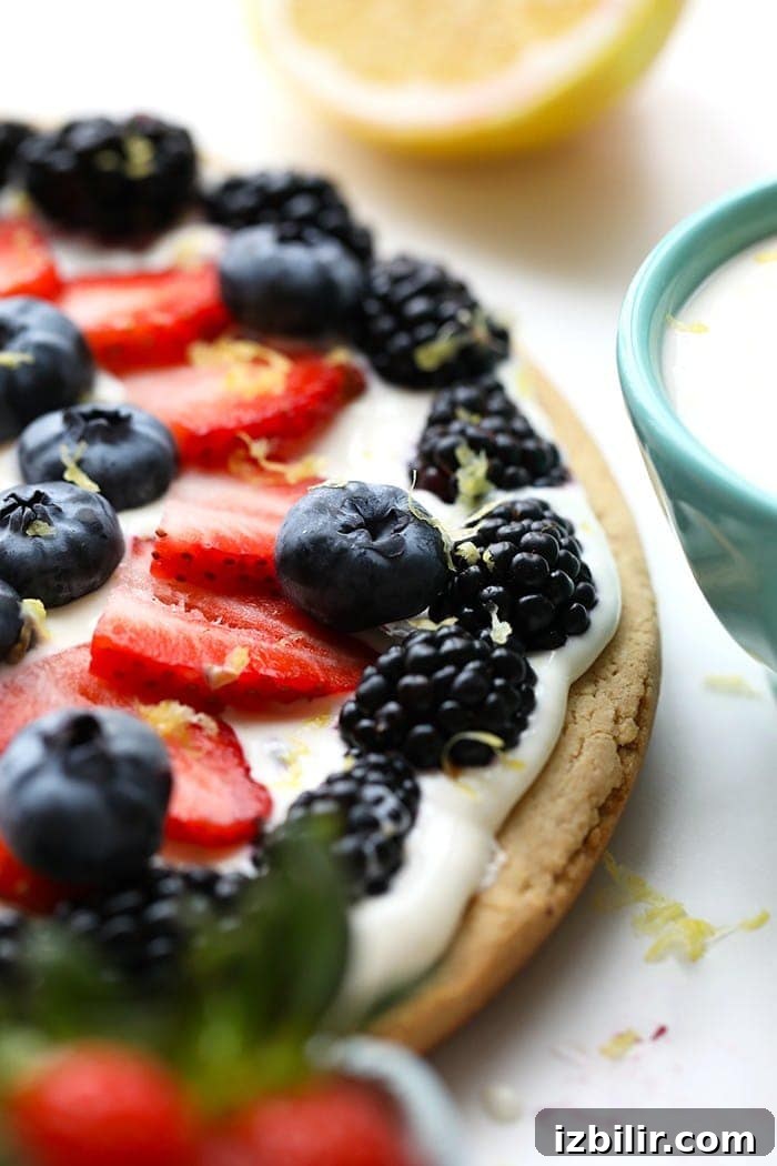 Delicious healthy fruit pizza with berries and lemon zest.