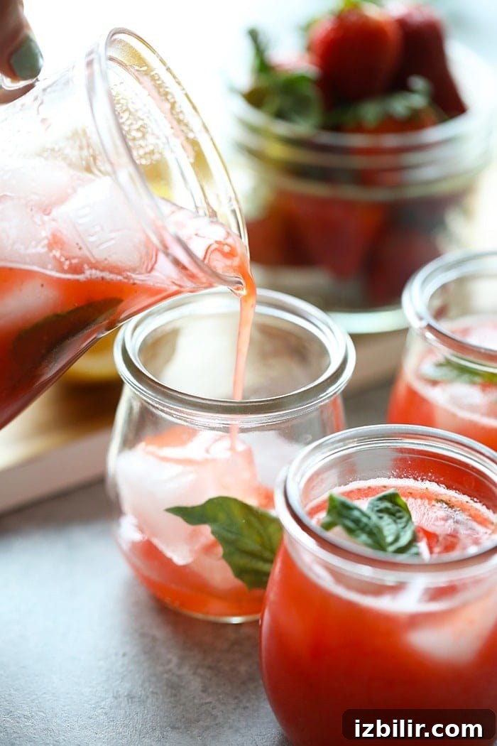 Refreshing Homemade Strawberry Lemonade Recipe 7 strawberry basil lemonade being poured into a glass