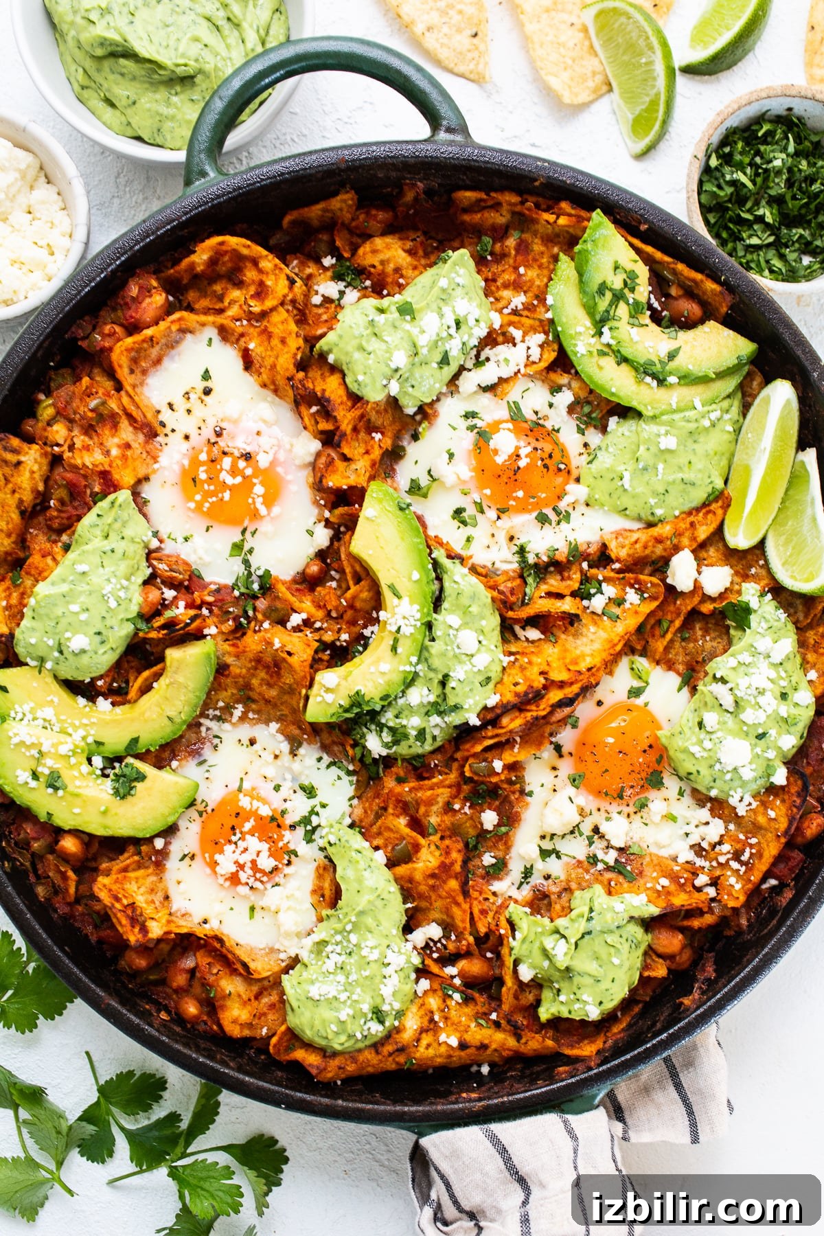 Chilaquiles with avocado crema in cast iron skillet. chilaquiles with avocado crema in cast iron skillet.