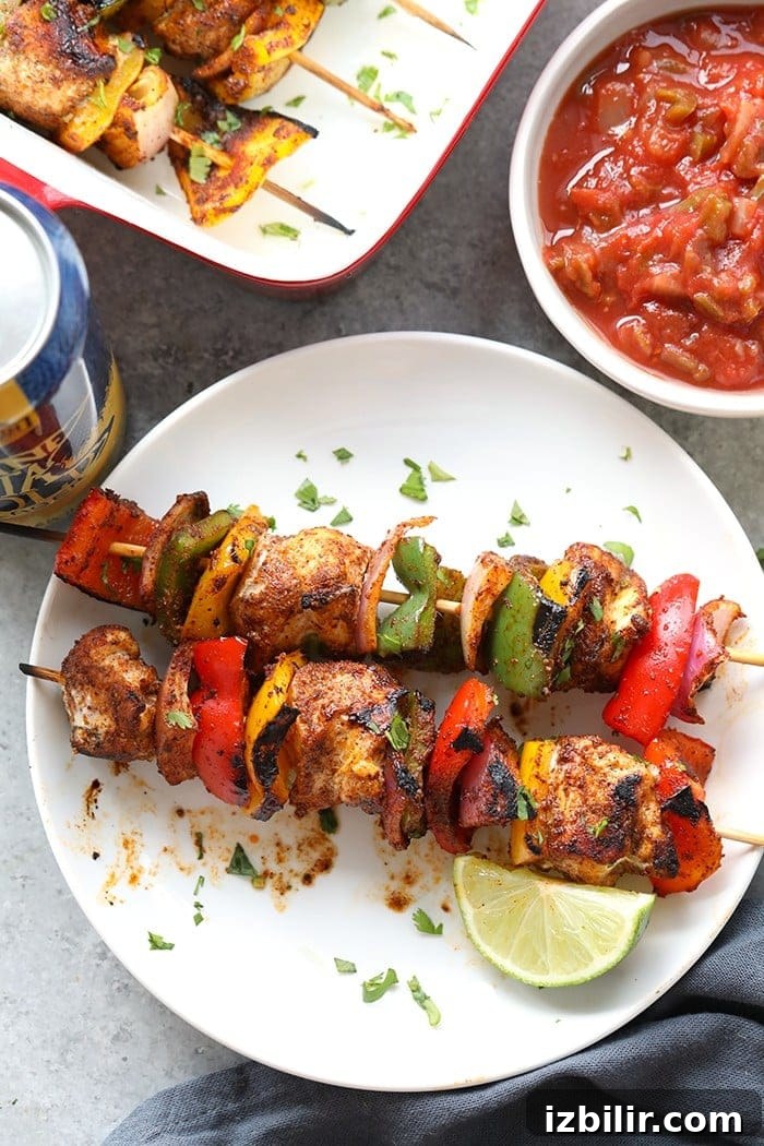 Serve kabobs on their own, or build a bowl or taco with rice, beans, and toppings. chicken fajita kabobs on plate.