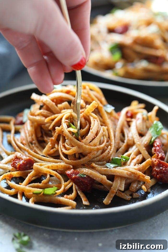 Pasta can be a healthy dinner packed with flavor and deliciousness. Substituting whole wheat pasta, adding vegetables, and creating a flavorful sauce is the key a healthy pasta for dinner. Treat yourself to this Whole Wheat Sun Dried Tomato Basil Pasta. It's light, fresh, and only require a few simple ingredients! sun dried tomato pasta with whole wheat pasta twirled on fork