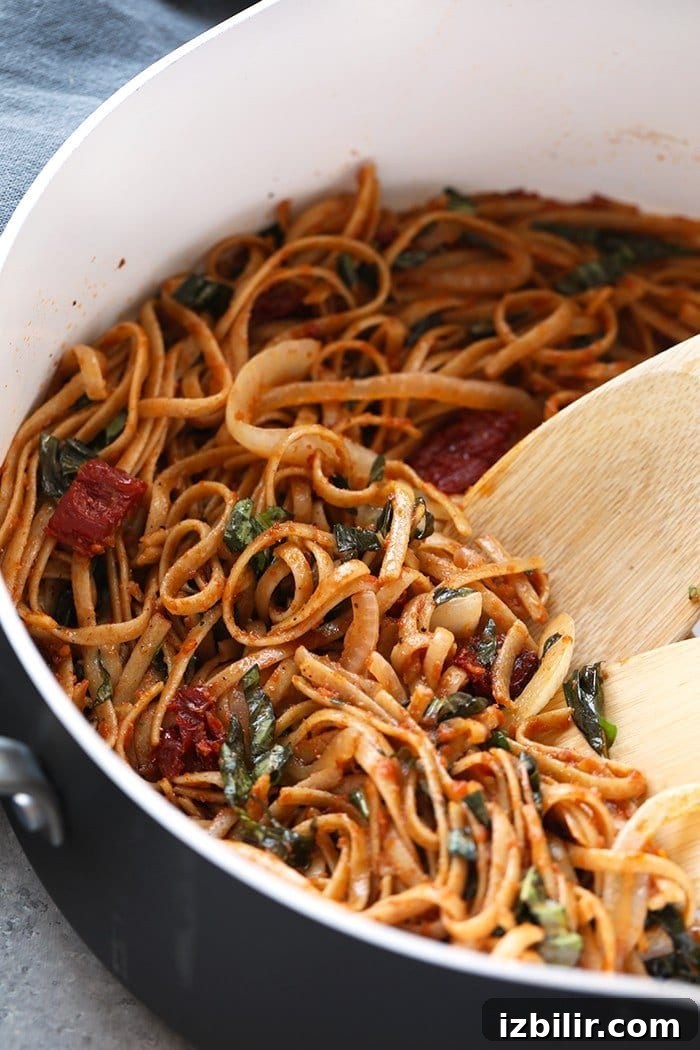 Pasta can be a healthy dinner packed with flavor and deliciousness. Substituting whole wheat pasta, adding vegetables, and creating a flavorful sauce is the key a healthy pasta for dinner. Treat yourself to this Whole Wheat Sun Dried Tomato Basil Pasta. It's light, fresh, and only require a few simple ingredients! sun dried tomato pasta with whole wheat noodles in pan