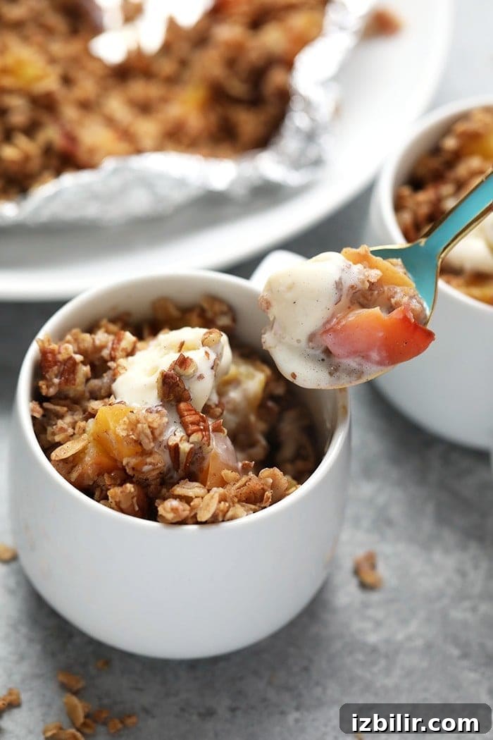Peach crumble in coffee mug with spoon.