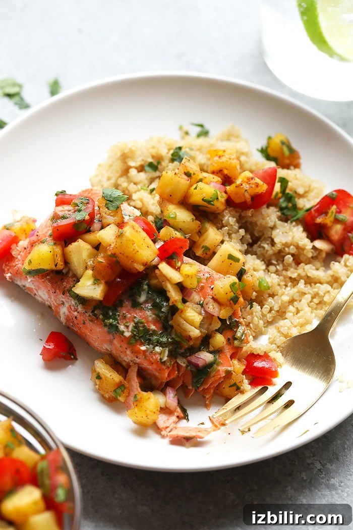 Grilled salmon on a plate with pineapple salsa.