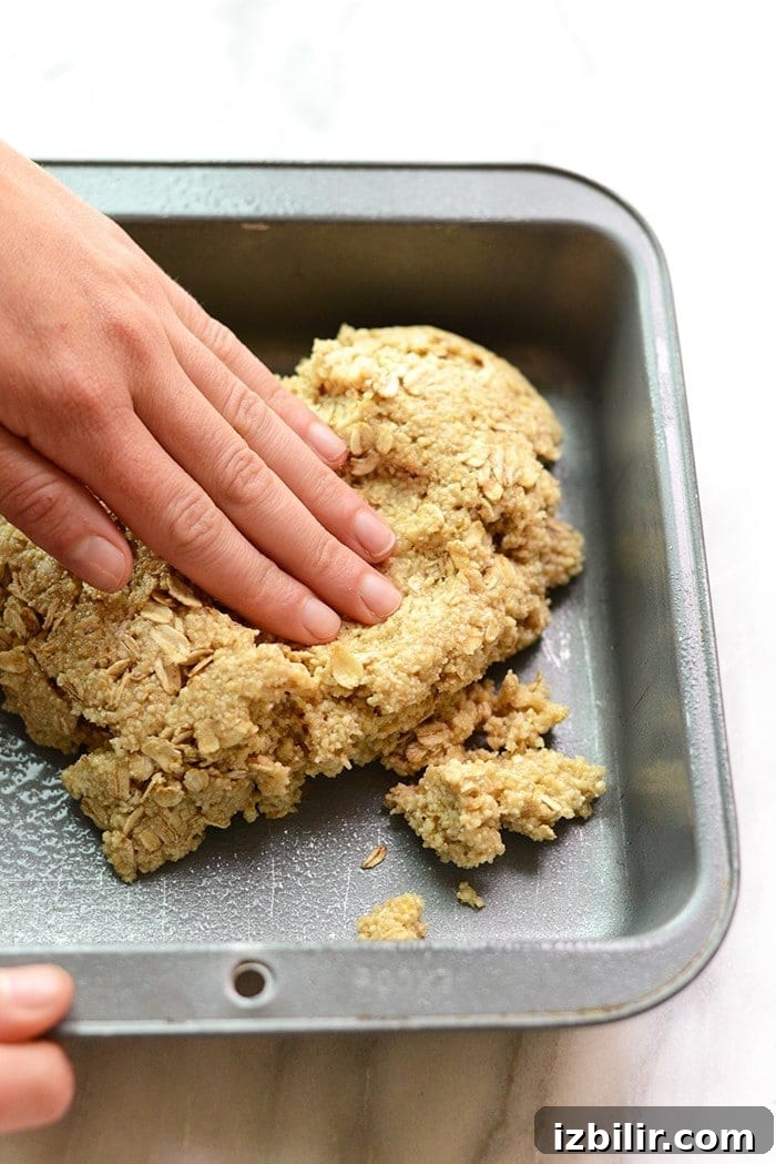 Zesty Lemon Blueberry Crumble Bars with Buttery Oat Crust 3 Pushing the almond flour crust into the pan.