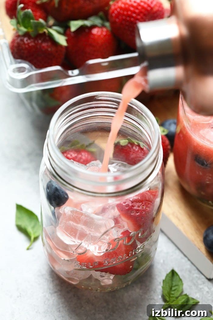 Strawberry Basil Kombucha Mocktail served with fresh basil and strawberries.