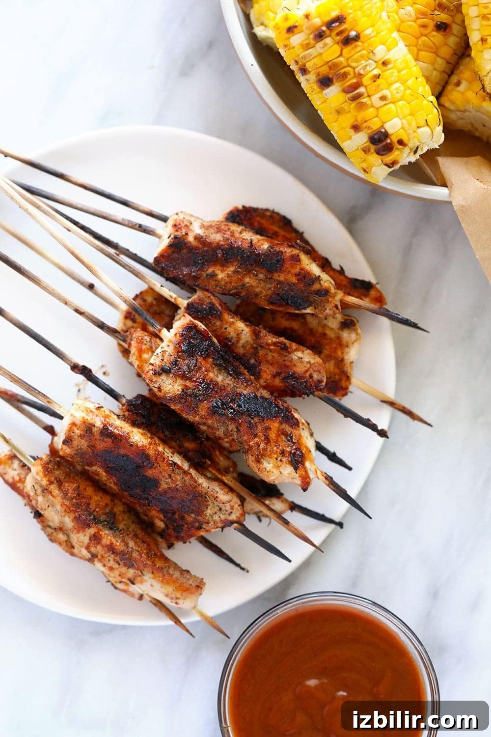 These BBQ Chicken Skewers are the perfect summer meal! Grab some skewers, BBQ sauce, and your favorite BBQ side dish and let's grill! Chicken Skewers on a plate.