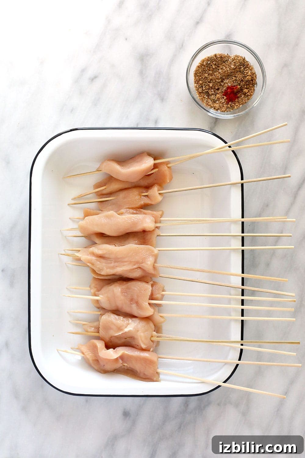 These BBQ Chicken Skewers are the perfect summer meal! Grab some skewers, BBQ sauce, and your favorite BBQ side dish and let's grill! Raw chicken on skewers.