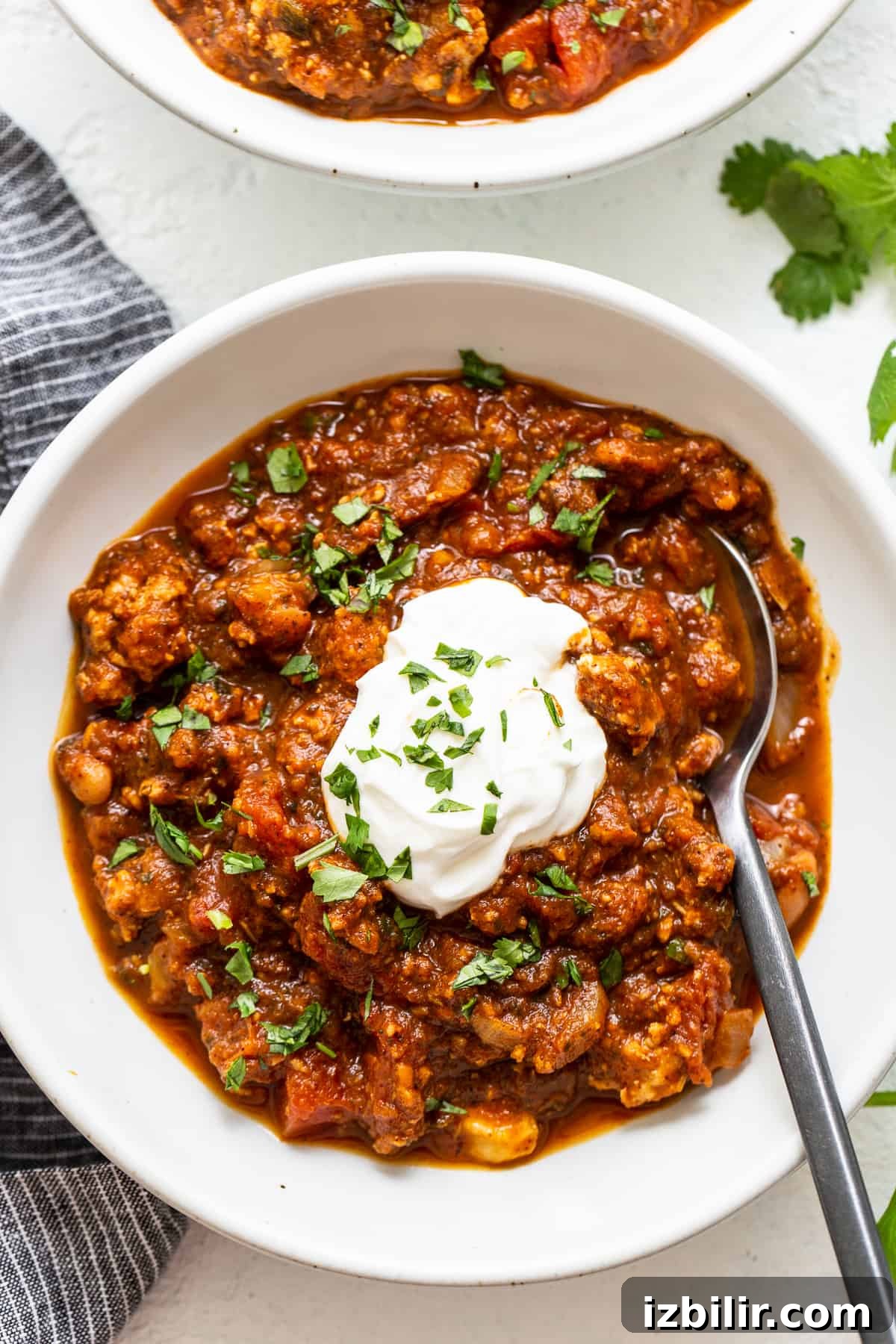 Pumpkin Chili Recipe for Cozy Fall Dinners 2 Pumpkin chili in a bowl topped with sour cream.