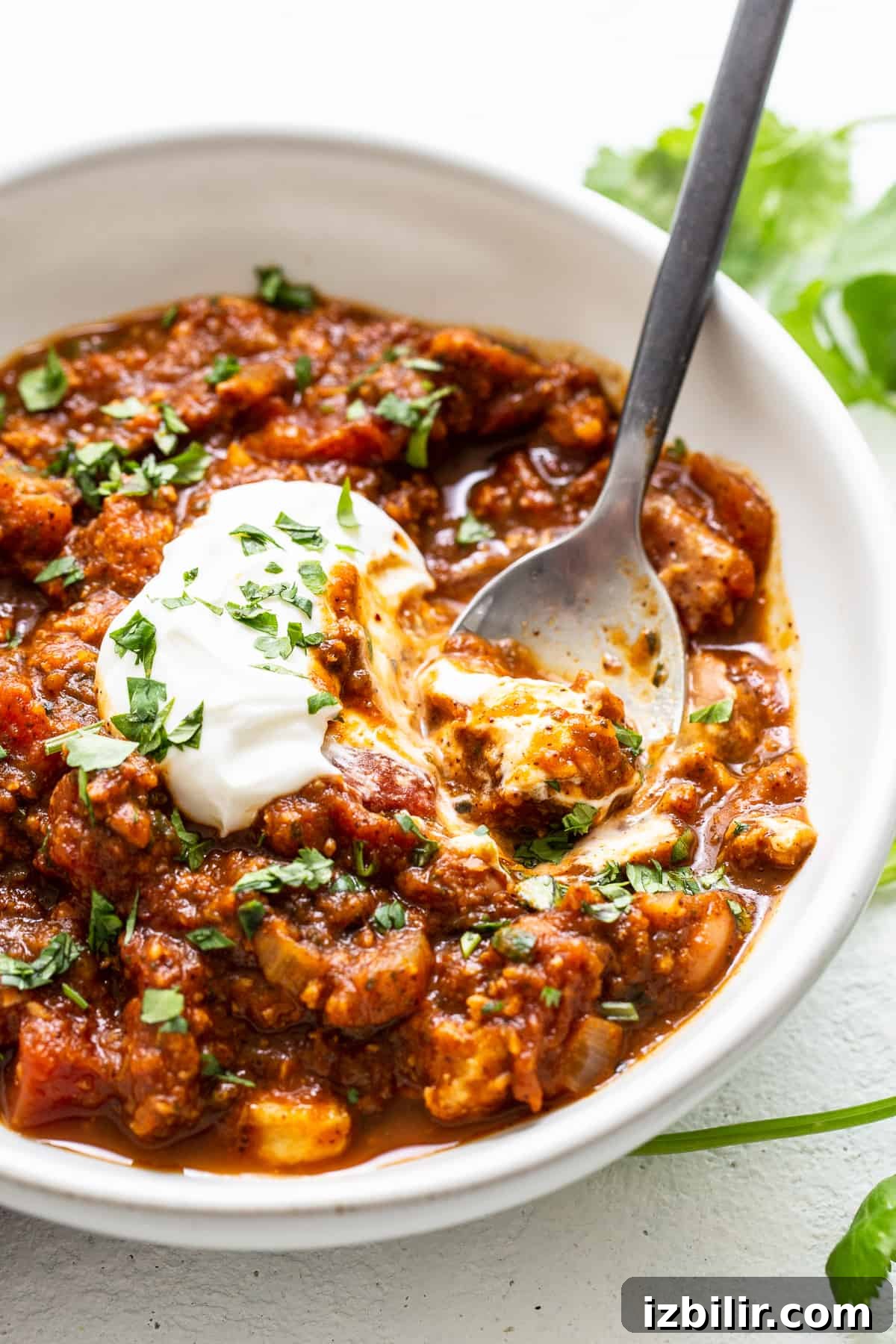 Pumpkin Chili Recipe for Cozy Fall Dinners 6 Turkey chili in a bowl with a spoon.