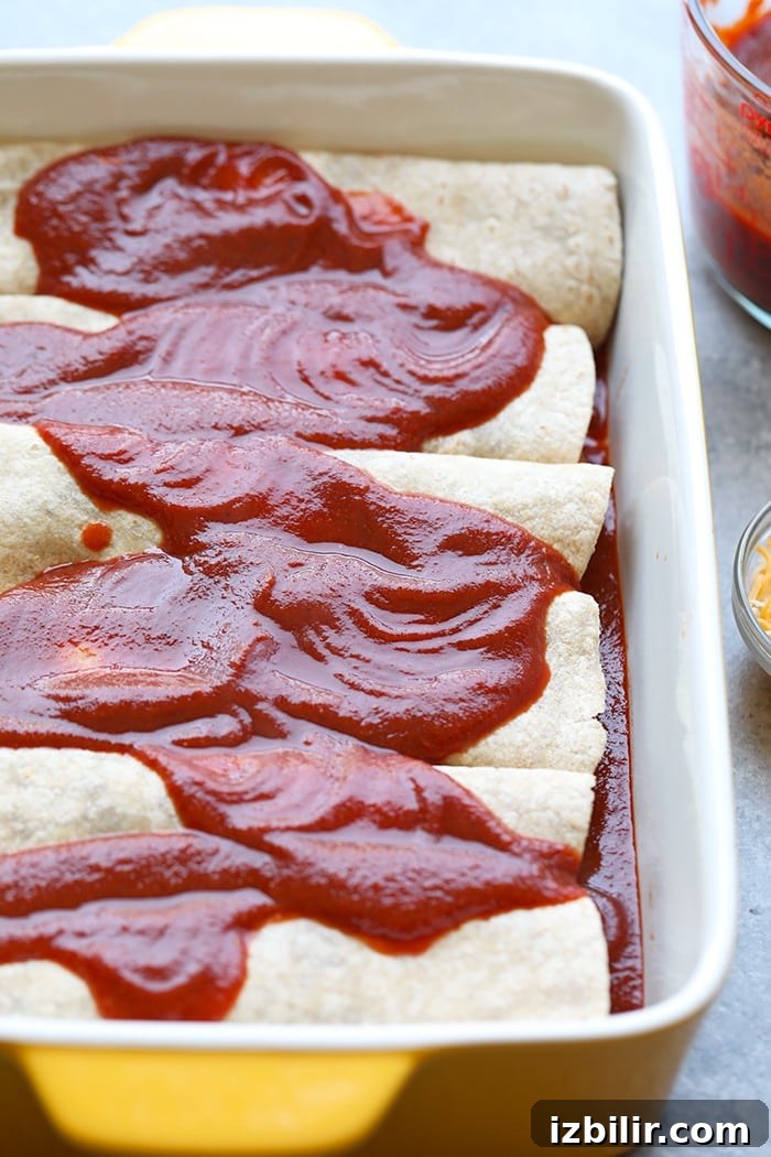healthy enchiladas covered with homemade enchilada sauce in baking dish