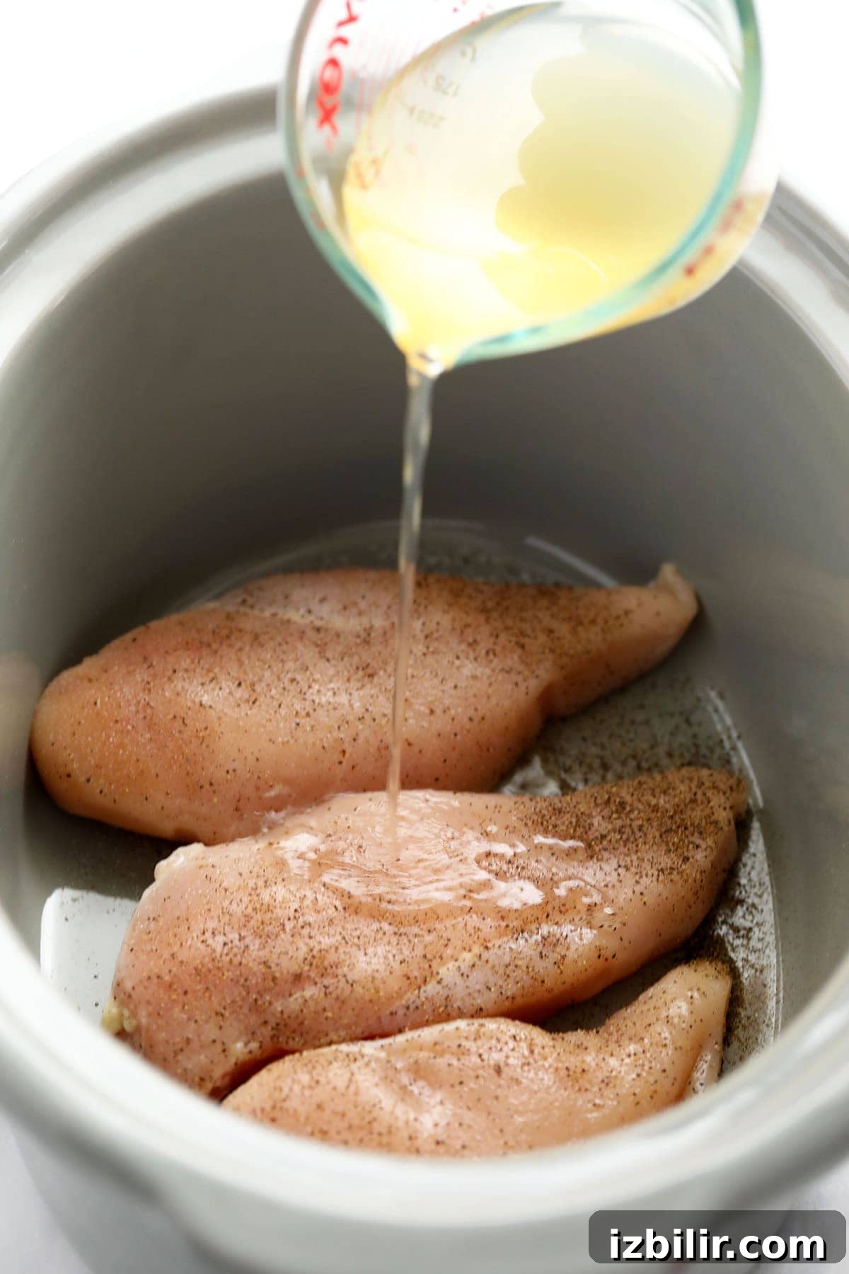 Crockpot Shredded Chicken for Tacos and Sandwiches 3 raw chicken in slow cooker with chicken broth