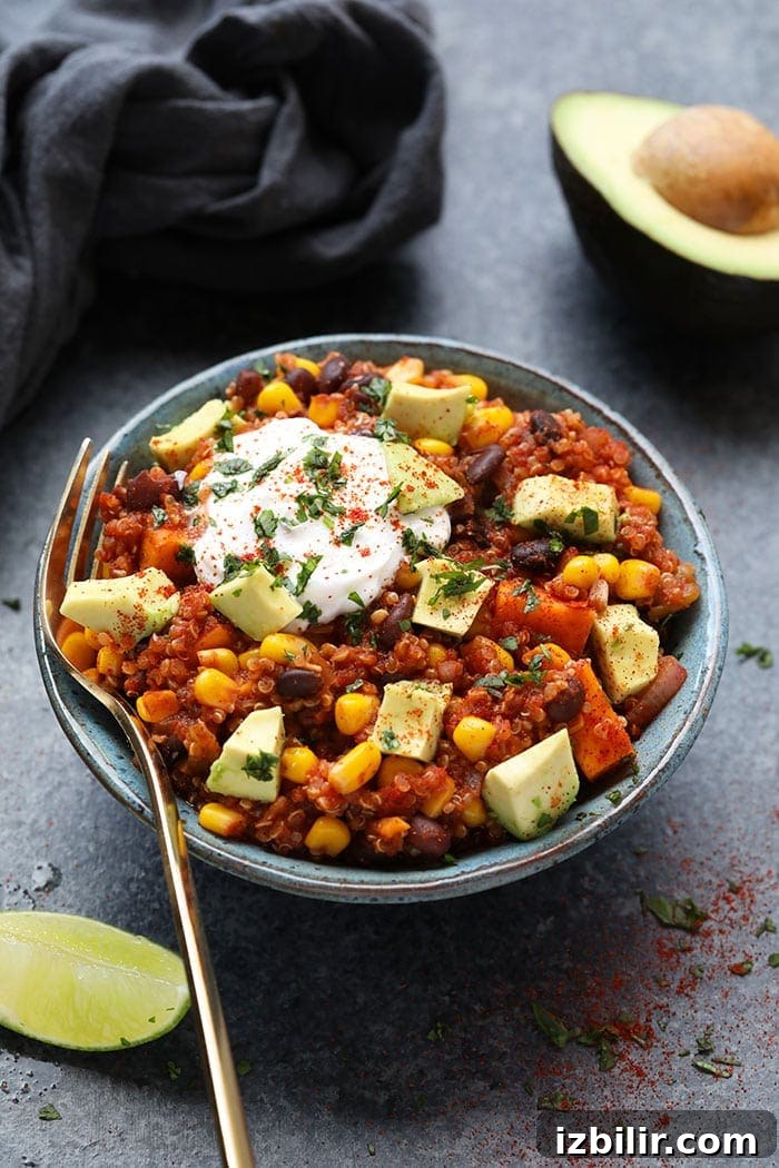 Slow cooker Mexican quinoa with sweet potatoes and beans Mexican quinoa in bowl with yogurt and sliced avocado