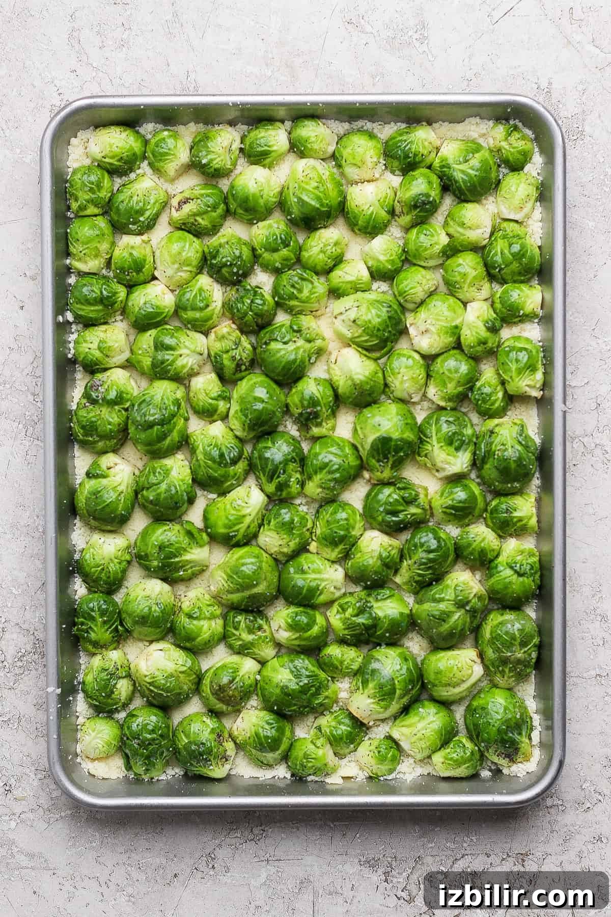 Crispy Parmesan-Crusted Brussels Sprouts Recipe 6 A baking tray filled with halved Brussels sprouts arranged in a single layer, ready to be roasted.