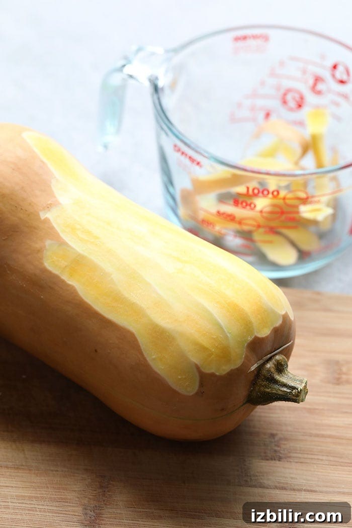 Peeled butternut squash on cutting board
