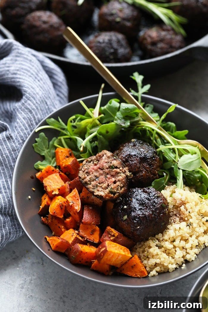 Meatballs served with quinoa, sweet potatoes, and arugula Rosemary Thyme Balsamic Meatballs in a bowl with quinoa, sweet potatoes, and arugula