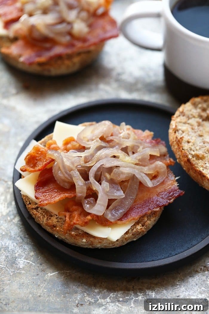 Arugula Breakfast Sandwich with Caramelized Onions — close-up view of sandwich layers.