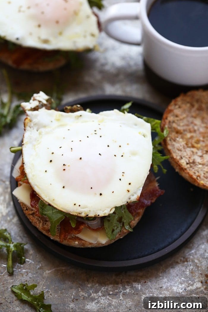 Finished arugula breakfast sandwich with caramelized onions, served and ready to eat.