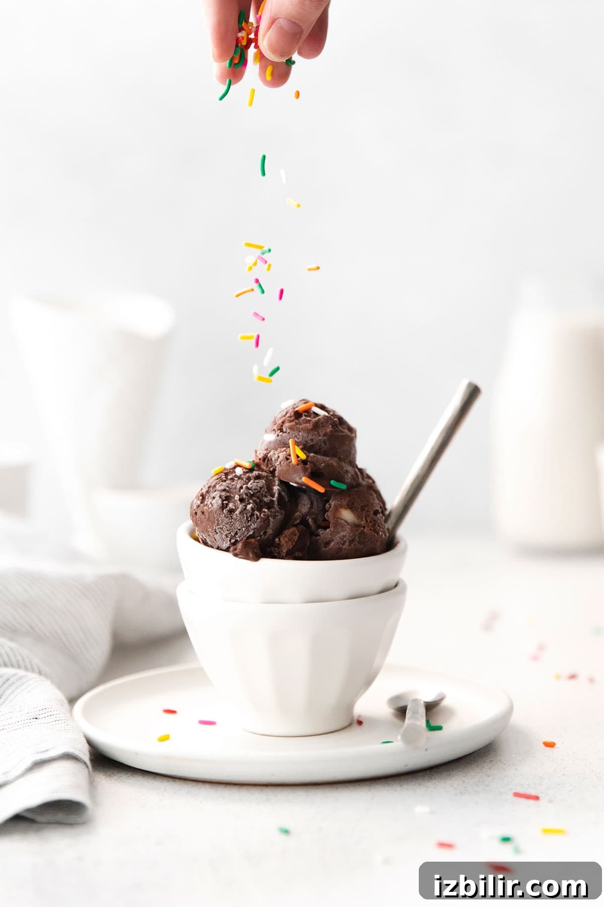 Sprinkling sprinkles on ice cream.