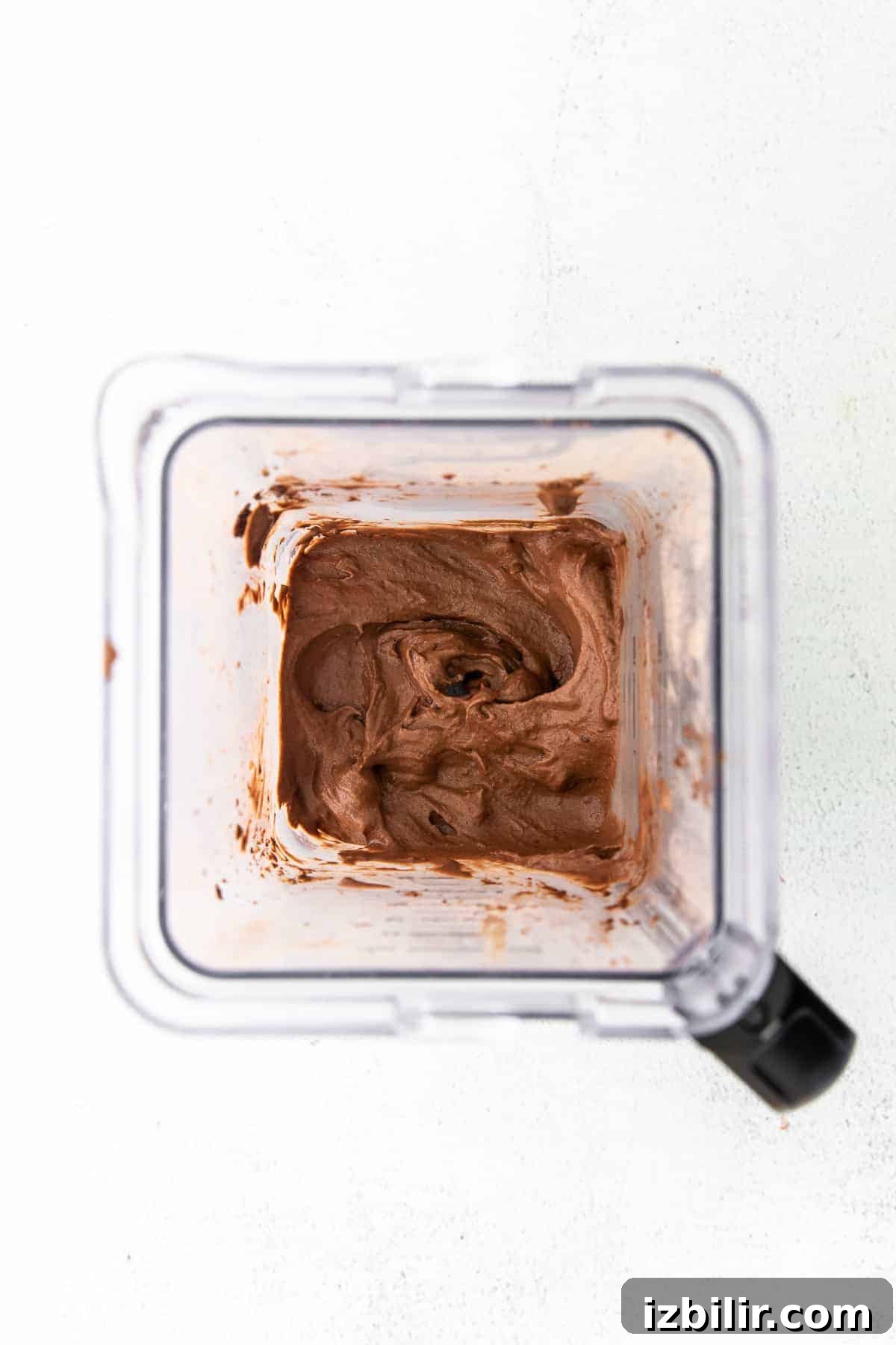 Blending chocolate protein ice cream in a blender.