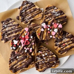No-Bake Peanut Butter Crunch Cups Recipe 3 Heart-shaped cookies and peanut butter cups on a plate.