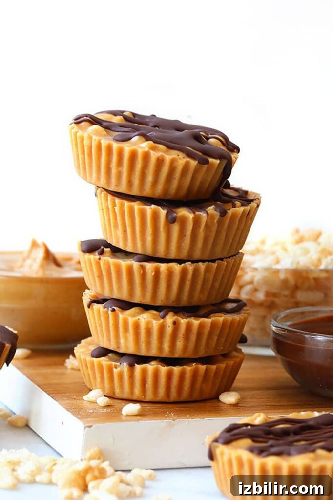 No-Bake Peanut Butter Crunch Cups Recipe 6 A stack of peanut butter cups on a cutting board.