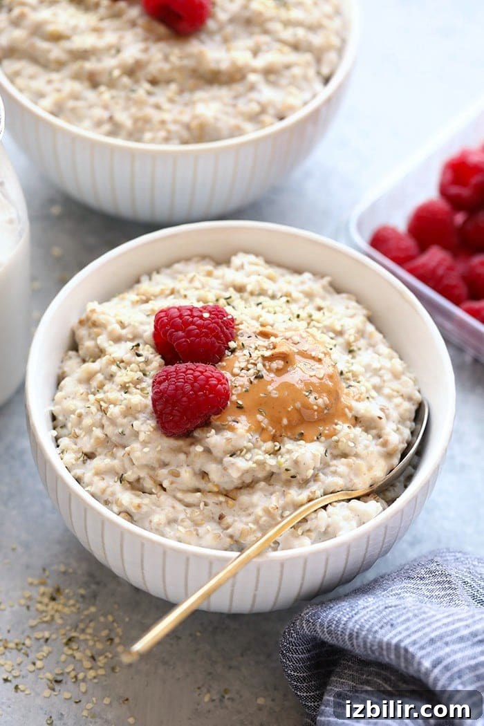 Steel cut oats in bowl with nut butter and raspberries.