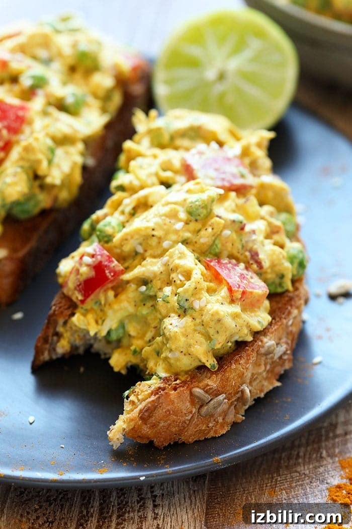This Curry Chicken Salad is a healthy chicken salad recipe that the whole family will love! It's packed with flavor and protein and is a great meal-prep for lunch or for a busy weeknight meal. Give this easy chicken salad recipe a try today! A bite taken out of a curry chicken salad sandwich