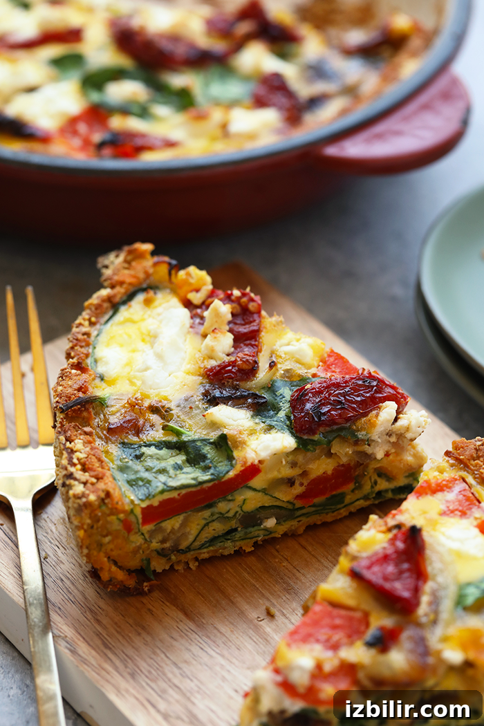 This sweet potato crust quiche has the most amazing crust that's made with sweet potatoes and almond flour. The quiche is packed with eggs, veggies, and goat cheese. slice of quiche on cutting board