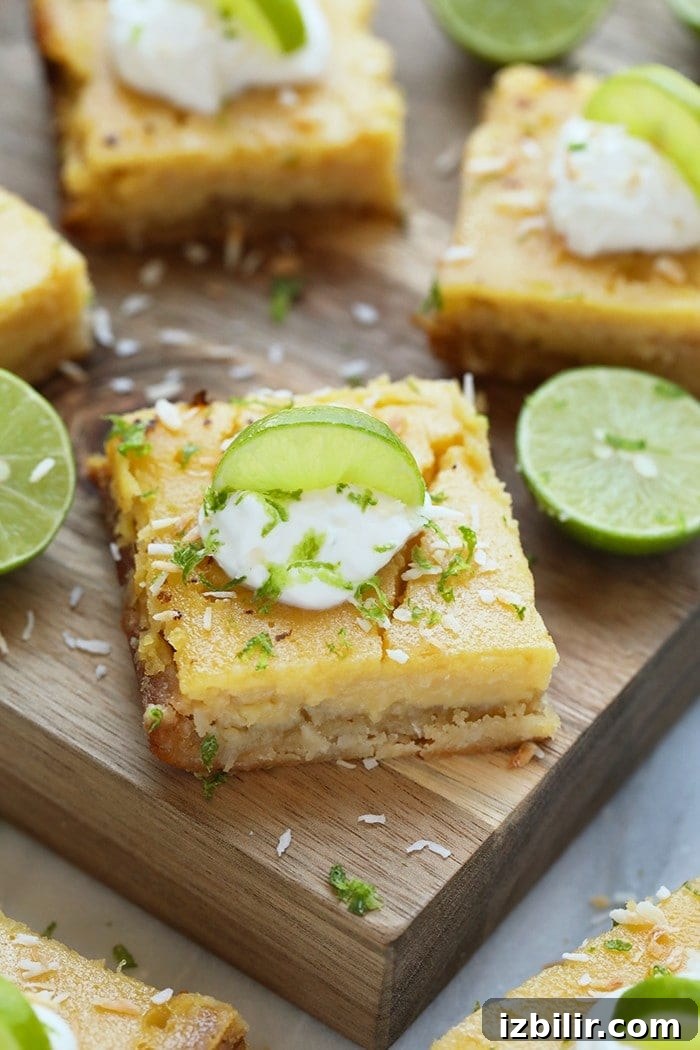 These easy coconut key lime pie bars are one of the tastiest healthy desserts! Naturally sweetened with honey and a coconut crust. key lime pie bar on a cutting board