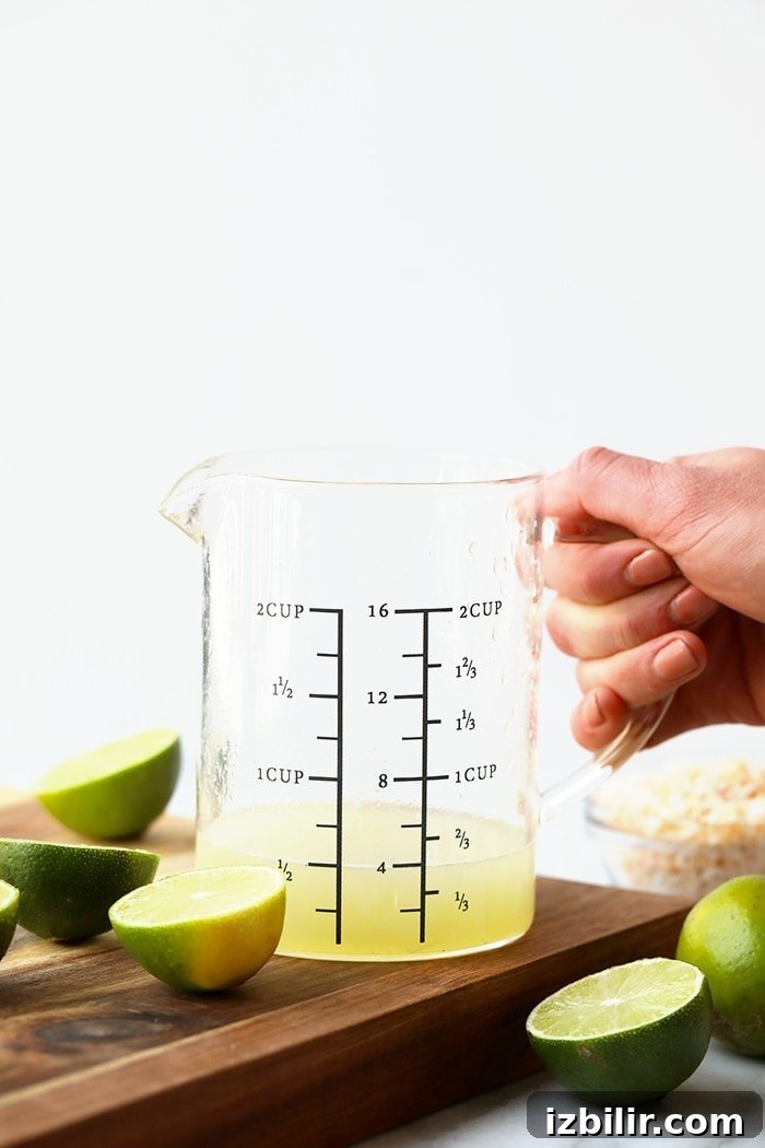 Key lime juice for a tart and refreshing filling. Measuring cup full of key lime juice