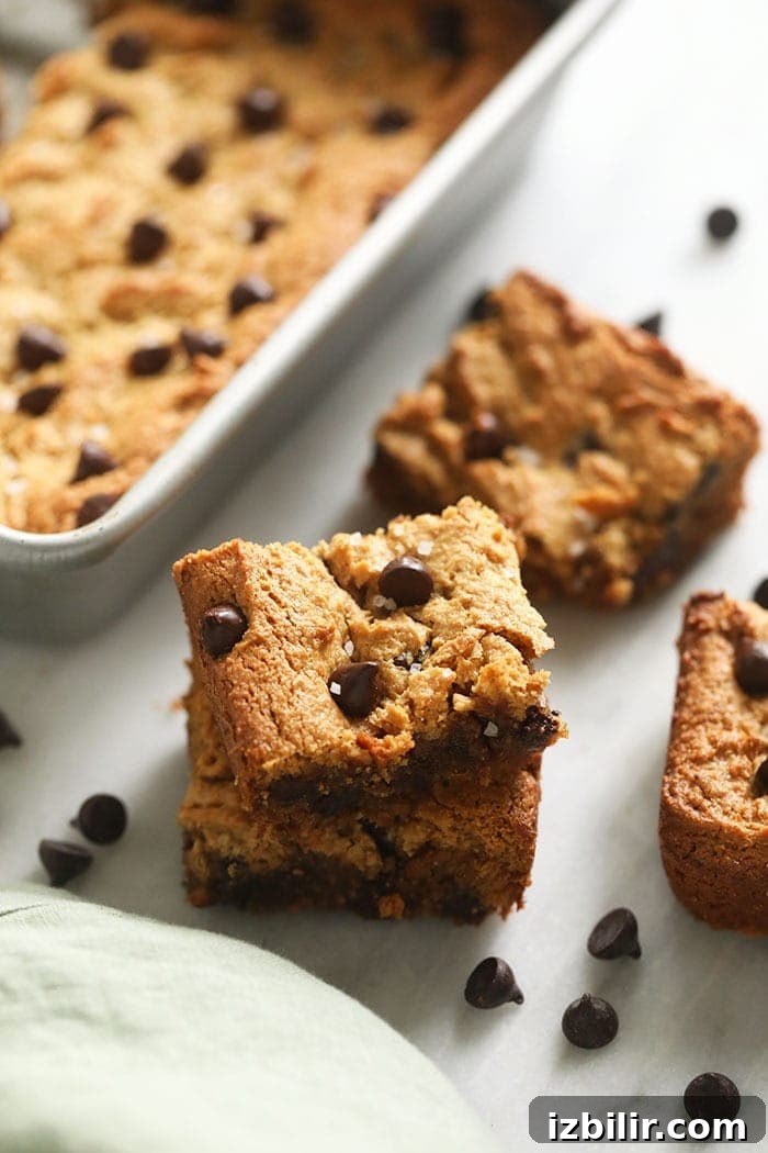 Flourless blondies so gooey you can't even tell they're healthy! Made with cashew butter, coconut flour, and dark chocolate chips, this is the only blondie recipe you'll ever want to make again. 2 blondies bars stacked