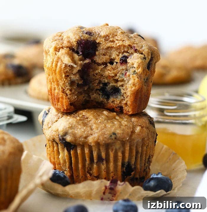 These healthy blueberry muffins are made with 100% whole grains and naturally sweetened with bananas and honey. At only 161 calories per muffin, you're going to love this healthy snack. healthy blueberry muffins stacked