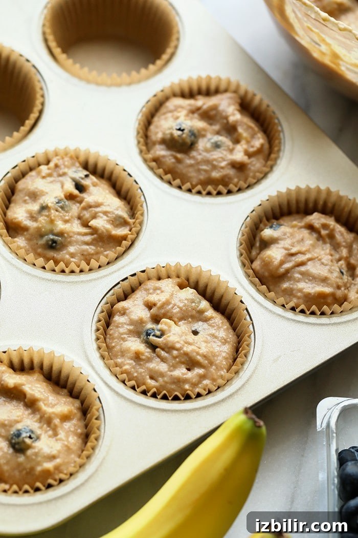 These healthy blueberry muffins are easy to whip up for a picnic or a healthy snack the whole family will enjoy! Muffin liners with batter in them