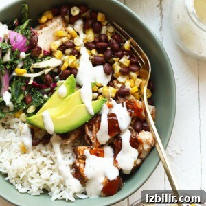 A bowl with BBQ chicken, rice, beans, corn, and avocado