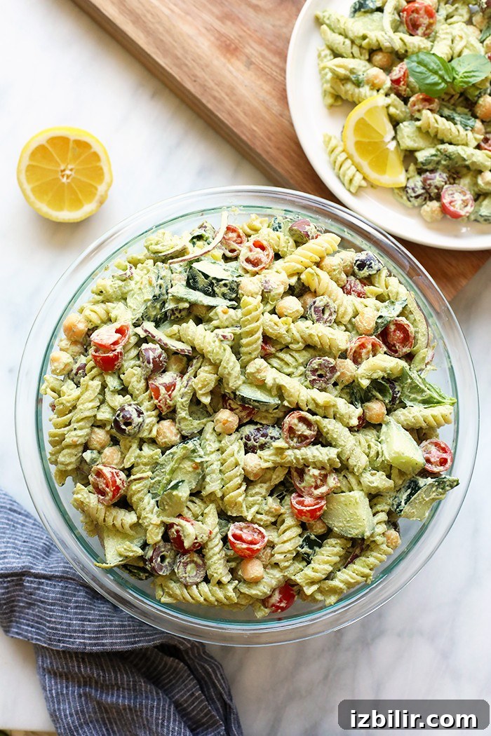 Creamy Greek Pasta Salad with Cashew Vegan Pesto made with seasonal produce and your favorite pasta. Vegan pasta salad in a bowl.