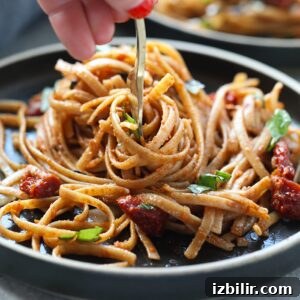 Sun dried tomato pasta being twirled on fork