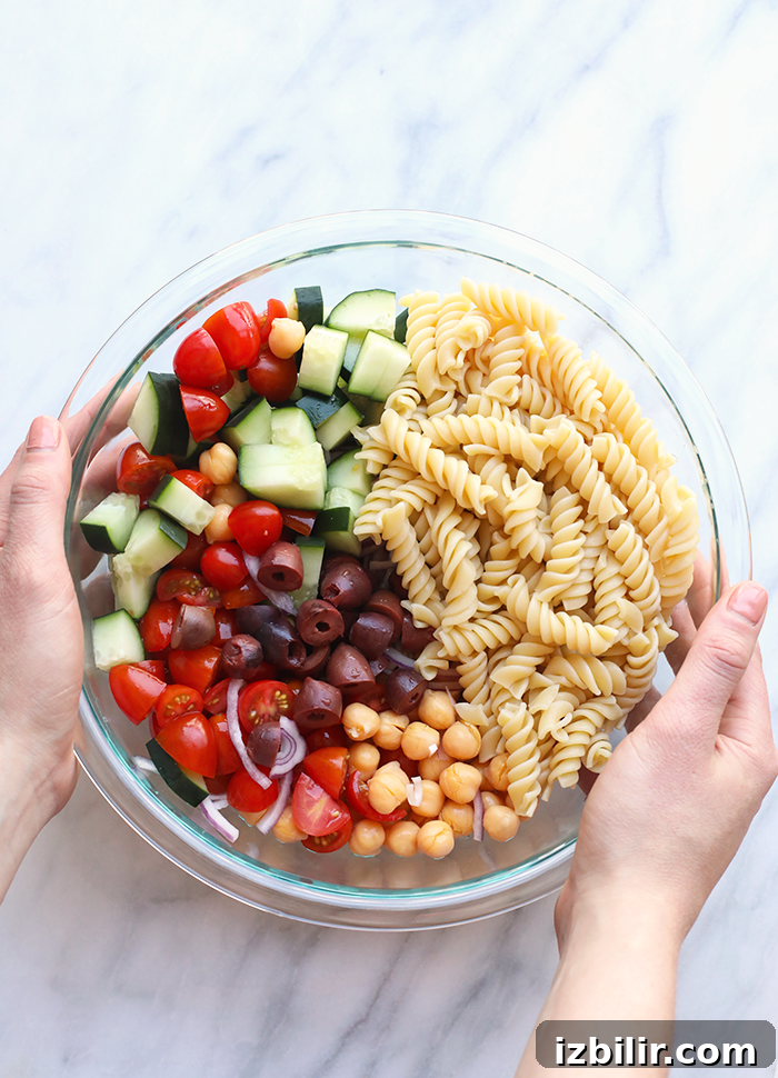 Creamy Greek Pasta Salad with Cashew Vegan Pesto, made with seasonal produce. Pasta salad in bowl.