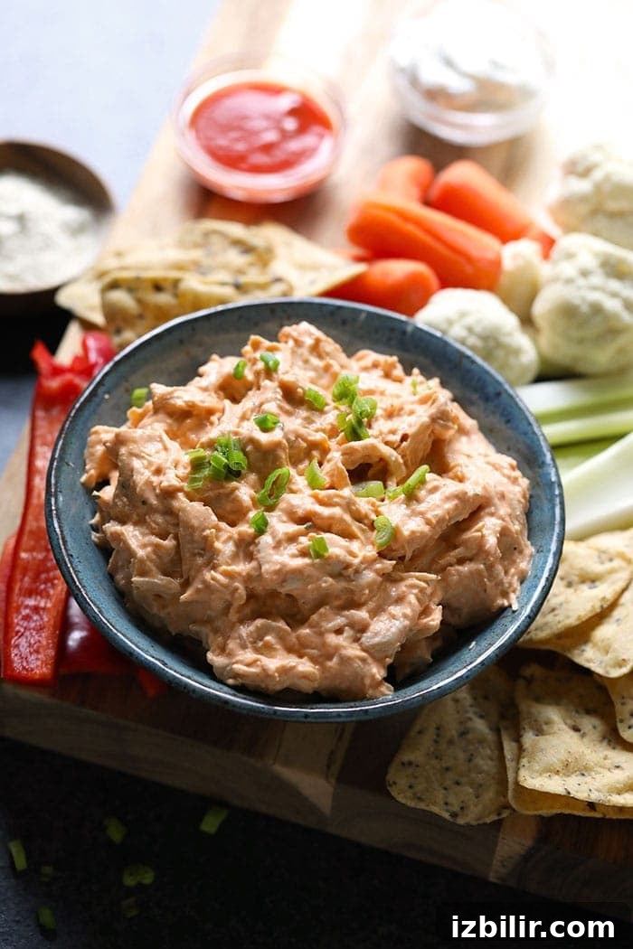 Crockpot Buffalo Chicken Dip buffalo chicken dip and fixings on a cutting board.