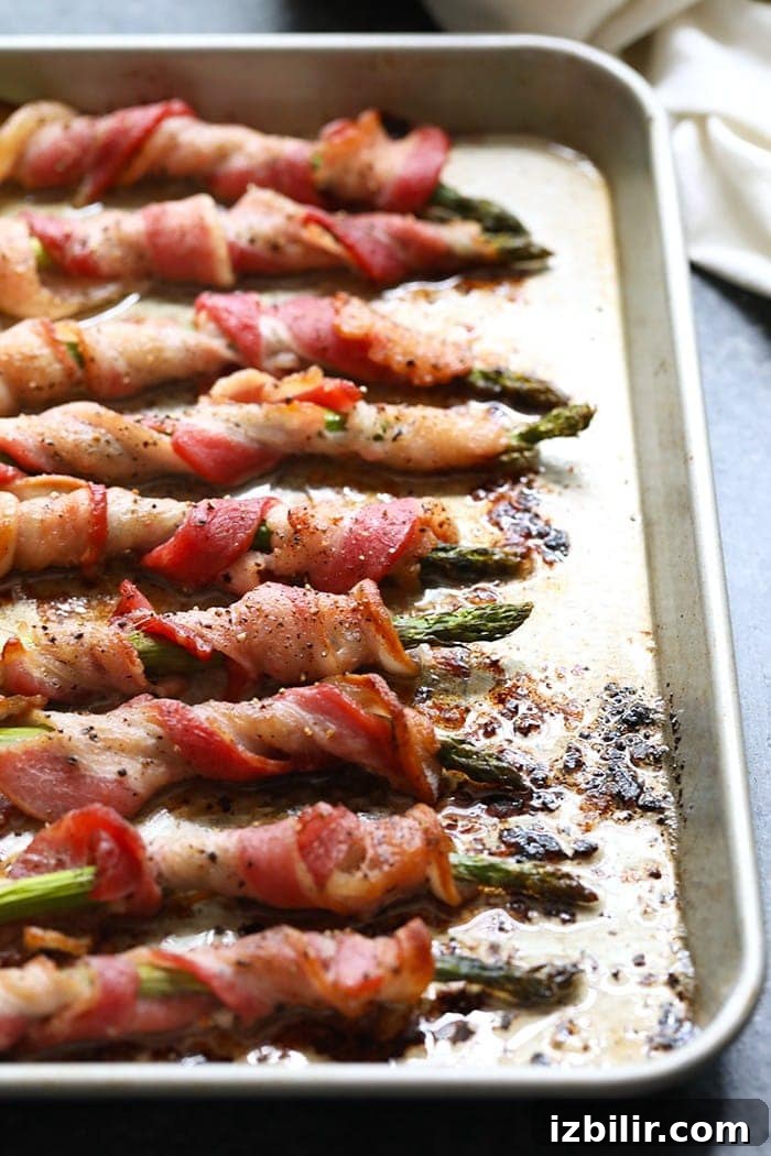 Bacon Wrapped Asparagus Bacon wrapped asparagus on a baking sheet