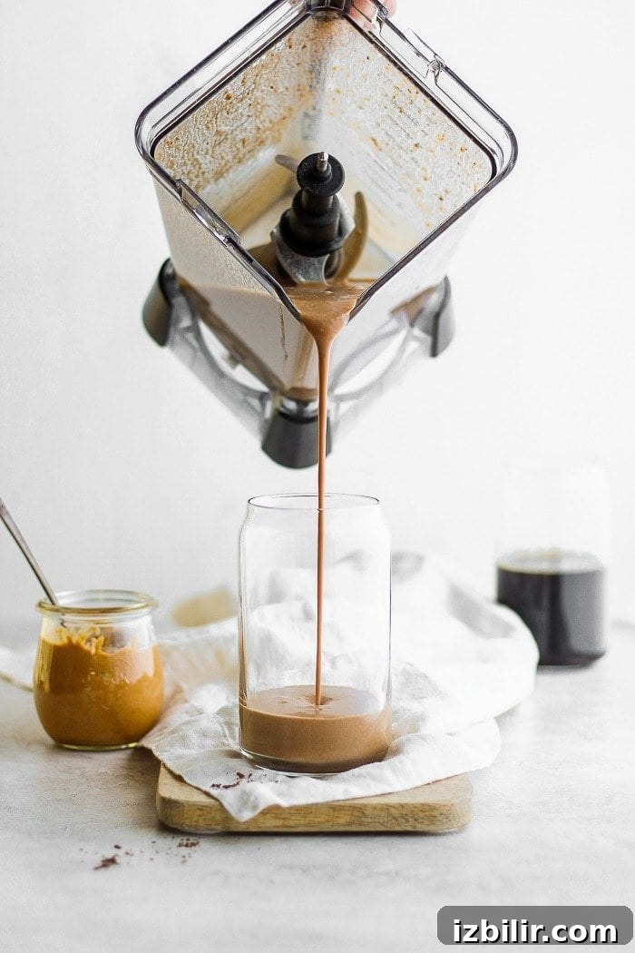 A protein smoothie being poured into a glass