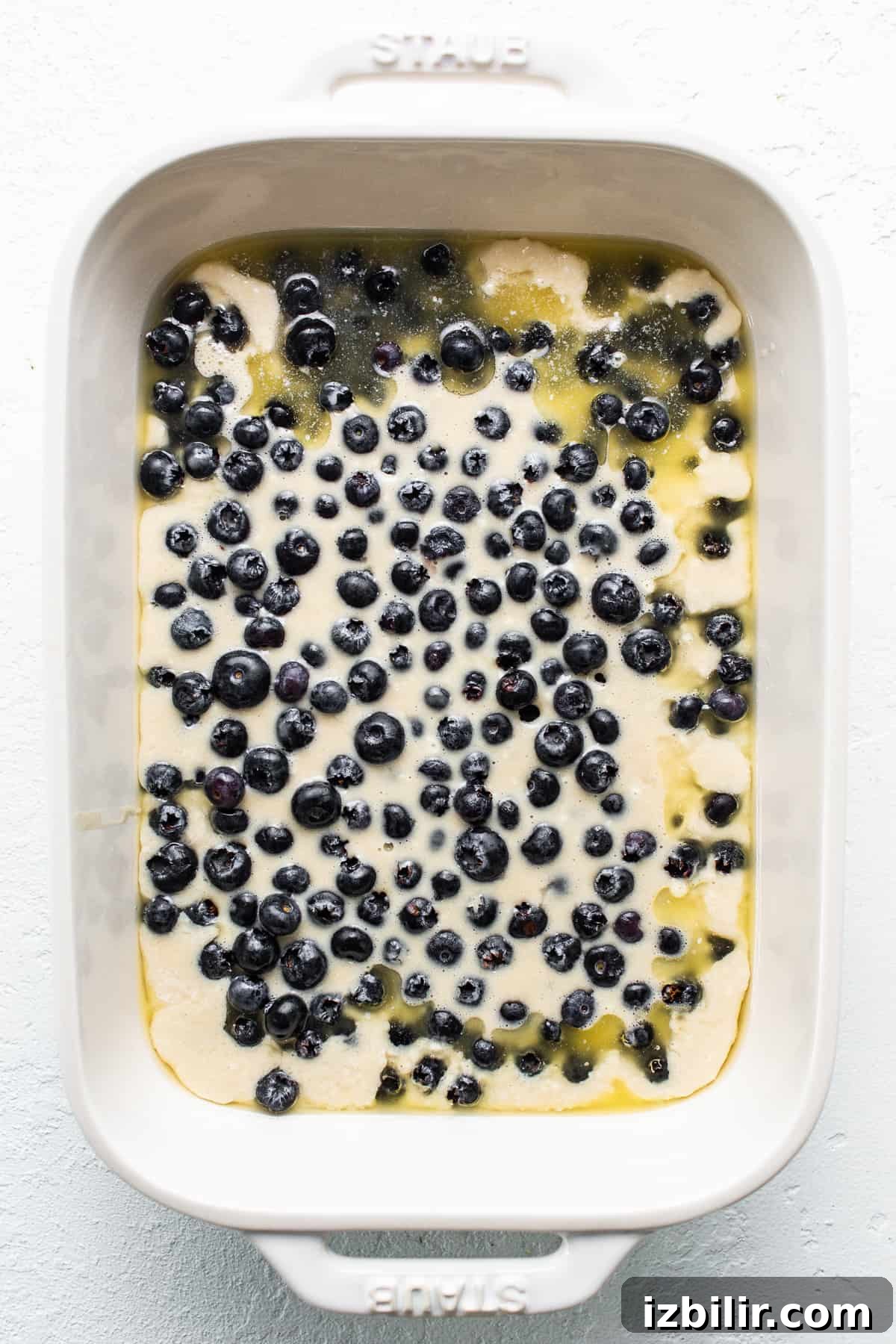 Uncooked blueberry cobbler in a baking dish. uncooked blueberry cobbler in baking dish.