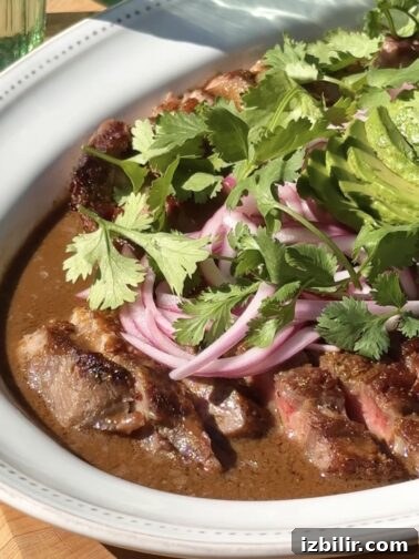 Aguachile de Ribeye plated with avocado and cilantro