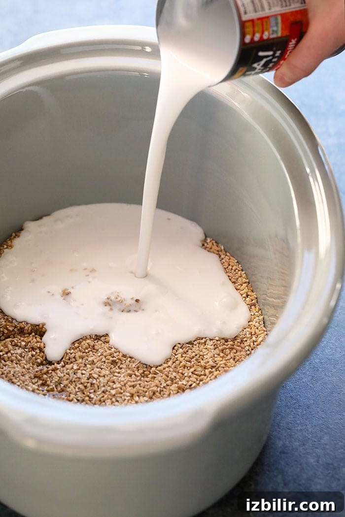 Pouring coconut milk over oats Coconut milk being poured over oats in a slow cooker