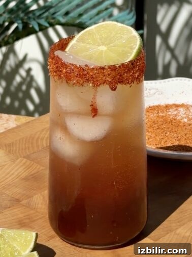 Michelada Mocktail in a tajín-rimmed glass with lime